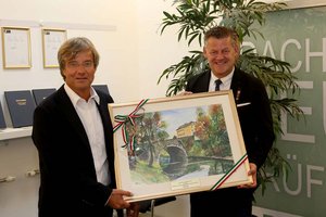 Bürgermeister Christian Scheider überreichte Otmar Petschnig (F&P Unternehmensgruppe) als Geschenk ein Gemälde von Klagenfurt. Foto: StadtKommunikation/Krainz