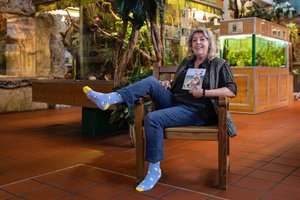 Reptilien-Expertin Helga Happ mit ihren frisch erstandenen Socken aus dem Onlineshop der Caritas. Foto: Caritas