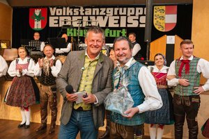 Bürgermeister Christian Scheider überreichte für 90 Jahre Volkstanzgruppe Edelweiss den Gläsernen Lindwurm an Vereinsobmann Roman Andrejcic. Foto: StadtKommunikation/Zangerle
