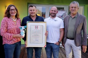 Stadträtin DI Constance Mochar und Stadtrat Max Habenicht überreichen Georg Findenig die Ehrenurkunde der Landeshauptstadt Klagenfurt. Foto: StadtKommunikation / Wajand
