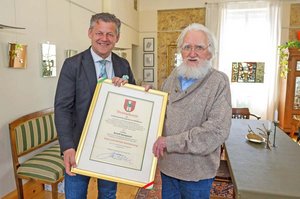 Bürgermeister Christian Scheider überreicht die Ehrenurkunde der Landeshauptstadt Klagenfurt an Prof. Arnulf Komposch. Foto: StadtKommunikation/Hude