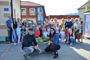 Landesrätin Sara Schaar (links bzw. vorne) und Künstler Heimo Luxbacher mit Kindern, Seniorinnen und Senioren sowie Pädagoginnen und Pädagogen bei der Enthüllung der Lichtsäule in Grafenstein. Foto: Büro LR.in Schaar
