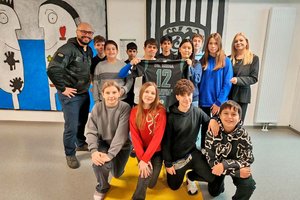 Literaturpreisträger und Spender John Patrick Platzer mit Direktorin Birgit Media und SchülerInnen der MS12. Foto: Soldaten mit Herz