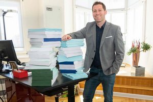Vizebürgermeister Philipp Liesnig zeigt, dass mit der Digitalisierung von Druckwerken viel Papier eingespart werden kann. Foto: StadtKommunikation/Wiedergut 