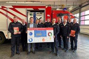 Feuerwehrreferent LR Daniel Fellner und Landesfeuerwehrkommandant Rudolf Robin (Mitte, mit Tafel) präsentierten den Tätigkeitsbericht des Kärntner Landesfeuerwehrverbandes 2024. Foto: Büro LR Fellner