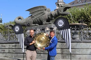 Bürgermeister Christian Scheider mit Mag. (FH) Thomas Tebbich, Geschäftsführer Wirtschaft des SK Sturm Graz, und dem Meisterteller am Neuen Platz in Klagenfurt. Foto: StadtKommunikation / Tilli