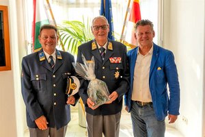 Albert Maryodnig bekam von Bürgermeister Christian Scheider im Beisein von Mag. Wilfried Kammerer, Einsatzleiter in Klagenfurt, den Gläsernen Lindwurm überreicht. Foto: StadtKommunikation / Zechner