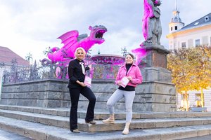 Stadträtin Sandra Wassermann, BA, und Theresa Neumann, BA MA, Geschäftsführerin der Österreichischen Krebshilfe Kärnten wiesen mit dem rosa beleuchteten Lindwurm auf das Thema Brustkrebsvorsorge hin. Foto: StadtKommunikation/Zangerle