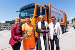 Entsorgungsreferentin Stadträtin Sandra Wassermann, Fahrer Stefan Sussitz, Pfarrer Dr. Emmanuel Longin und Bürgermeister Christian Scheider vor dem gesegneten Müllwagen. Foto: StadtKommunikation/Wiedergut