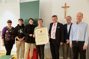 Bürgermeister Christian Scheider überreicht Klassensprecher Fabio Galle die Auszeichnung, am Bild mit Projektleiterin Anita Steurer, Direktor Hans Oman und Klassenvorstand Mario Klemen und Schülern. Foto: StadtKommunikation / D. Wajand