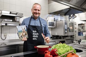 Haubenkoch Hubert Wallner mit seiner im Online-Shop der Caritas erstandenen Kochschürze. Foto: Johannes Leitner/Caritas