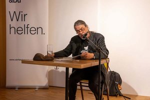Herwig Oberlerchner liest im magdas LOKAL „Geschichten aus der Psychiatrie“. Foto: Caritas